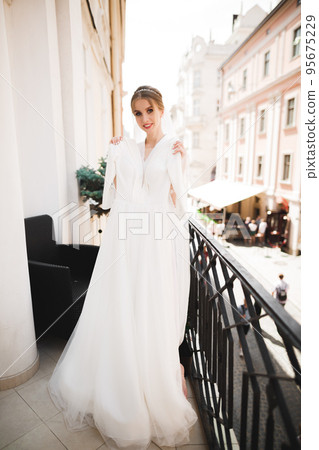 Luxury bride in white dress posing while preparing for the wedding ceremony Luxury bride in white dress posing while preparing for the wedding ceremony 95675229