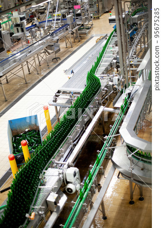Beer factory bottles on the line. Technological line for washing of glass bottles for beer. High Beer factory bottles on the line. Technological line for washing of glass bottles for beer. High 95675285