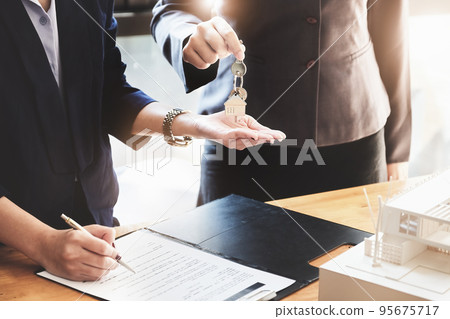 Real estate agents agree to buy a home and give keys to clients at their agency's offices. Concept agreement Real estate agents agree to buy a home and give keys to clients at their agency's offices. Concept agreement 95675717