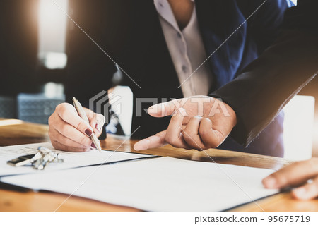 estate agent gives pen and documents agreement with customer to sign contract. Concept agreement 95675719