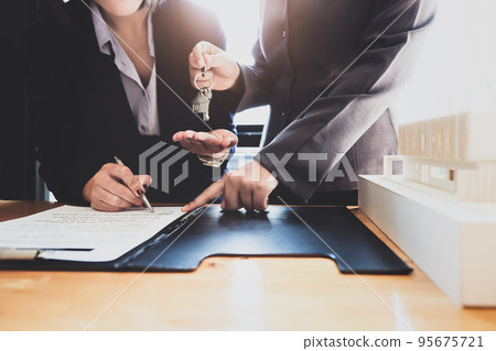 Real estate agents agree to buy a home and give keys to clients at their agency's offices. Concept agreement Real estate agents agree to buy a home and give keys to clients at their agency's offices. Concept agreement 95675721