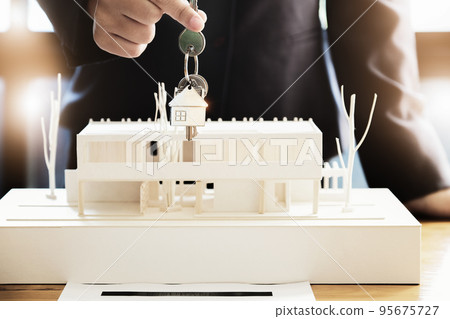 Real estate agents agree to buy a home and give keys to clients at their agency's offices. Concept agreement 95675727