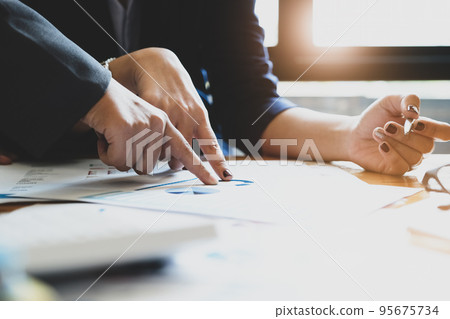 The company employee points to the budget document and makes marketing out of the budget being reviewed. 95675734