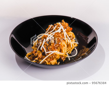 Pasta pappardelle with beef ragout sauce in black bowl. Grey background. Close up. Top view. Pasta pappardelle with beef ragout sauce in black bowl. Grey background. Close up. Top view. 95676384