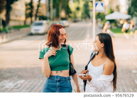 Happy women talking and laughing at the city street 95676529