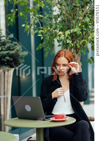 Beautiful woman working on laptop at outdoors cafe 95676551