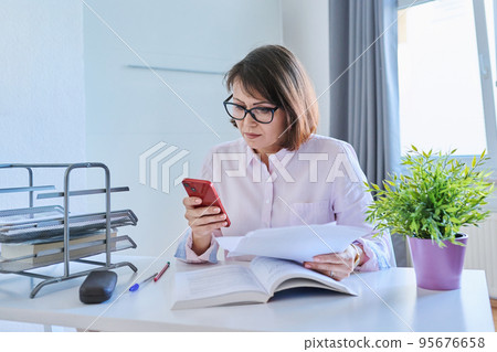 Middle aged business woman working at home Middle aged business woman working at home 95676658