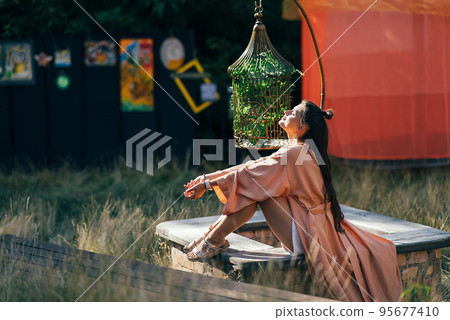 Brunette woman sitting on bench and enjoying the sunset 95677410