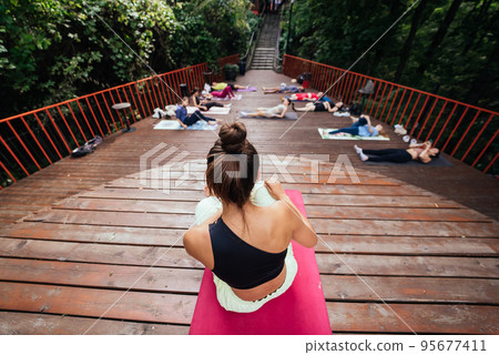 Group of young sporty people practicing yoga lesson with instructor, 95677411