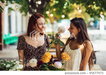 Two young women make up a beautiful festive bouquet. 95677473
