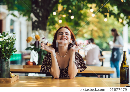 Close-up portrait of two female at summer street cafe 95677479