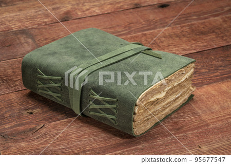 retro leather-bound journal on rustic wood 95677547