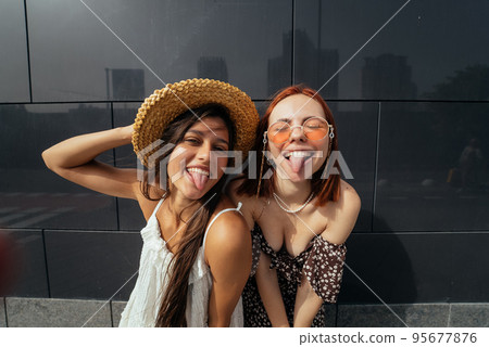 Two attractive young women fooling around in fresh air. Two attractive young women fooling around in fresh air. 95677876
