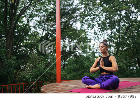 Young woman is practising yoga sitting in the lotus position 95677982