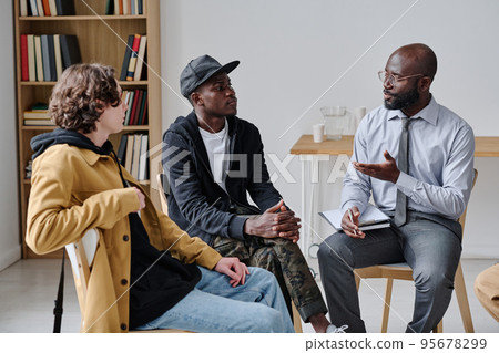 African coach talking to students and explaining them material at class African coach talking to students and explaining them material at class 95678299