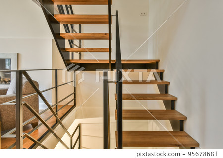 White spiral stairway connecting levels of contemporary house with wooden floor and white walls White spiral stairway connecting levels of contemporary house with wooden floor and white walls 95678681