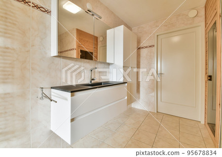 Glass partition between shower tap and wall hung toilet in modern restroom at home 95678834