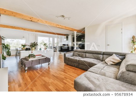 Contemporary minimalist style interior design of light studio apartment with wooden table and chairs in dining zone between open kitchen and living room with white walls and parquet floor 95678934
