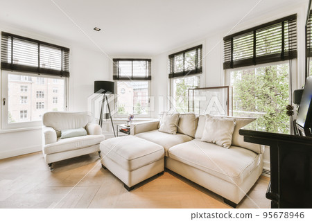 Contemporary minimalist style interior design of light studio apartment with wooden table and chairs in dining zone between open kitchen and living room with white walls and parquet floor Contemporary minimalist style interior design of light studio apartment with wooden table and chairs in dining zone between open kitchen and living room with white walls and parquet floor 95678946