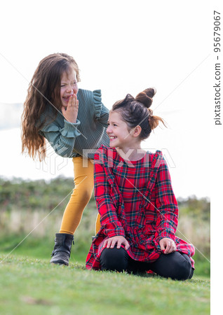 Two little girls sisters playing outdoor near Cuckmere beach located between Eastbourne and Seaford, East Sussex, British south coast, selective focus 95679067
