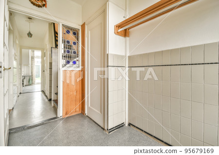 Corridor of contemporary apartment with black closets and opened doorway leading to terrace Corridor of contemporary apartment with black closets and opened doorway leading to terrace 95679169