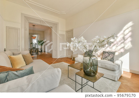 Fancy lamp hanging on ceiling over stylish furniture in spacious living room in modern flat Fancy lamp hanging on ceiling over stylish furniture in spacious living room in modern flat 95679170