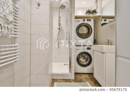 Flush toilet located between sink and shower in small tiled bathroom of contemporary apartment Flush toilet located between sink and shower in small tiled bathroom of contemporary apartment 95679178