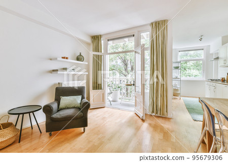 Shabby wooden table with chairs and vase located near comfortable couch against light walls with decorations in modern apartment Shabby wooden table with chairs and vase located near comfortable couch against light walls with decorations in modern apartment 95679306
