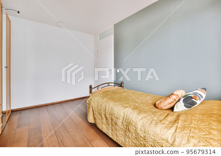 Home interior design of bedroom with bed and wooden wardrobe placed in corner near window in modern apartment 95679314
