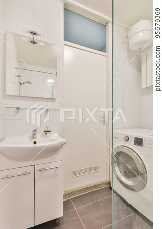 Sink base cabinet and mirror cabinet in white tiled bathroom with wall hung toilet Sink base cabinet and mirror cabinet in white tiled bathroom with wall hung toilet 95679369
