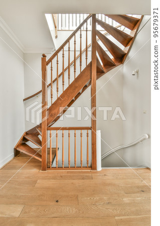 White hallway with wooden stairway leading to second floor of modern luxury apartment with minimalist interior design 95679371