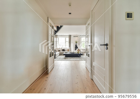 Light narrow hallway with many doors in white walls and glowing lamp over lumber floor Light narrow hallway with many doors in white walls and glowing lamp over lumber floor 95679556