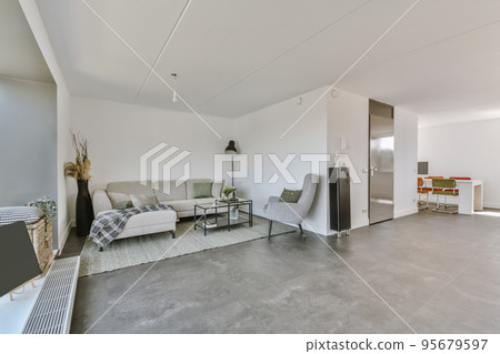 Comfortable sofa with cushions placed against light wall with TV and decorations in modern loving room Comfortable sofa with cushions placed against light wall with TV and decorations in modern loving room 95679597