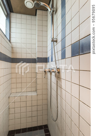 Sinks with mirrors and clean bathtub located near shower box in modern bathroom with white tiled walls Sinks with mirrors and clean bathtub located near shower box in modern bathroom with white tiled walls 95679895