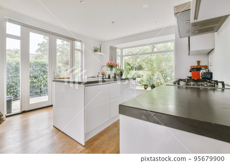 Home interior design of modern loft apartment with open kitchen in minimalist style and spacious dining zone with table and chairs Home interior design of modern loft apartment with open kitchen in minimalist style and spacious dining zone with table and chairs 95679900
