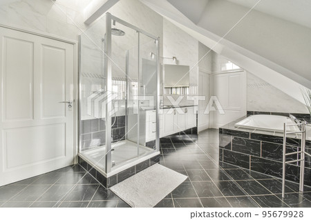 Sinks with mirrors and clean bathtub located near shower box with glass door in modern bathroom with white tiled walls 95679928