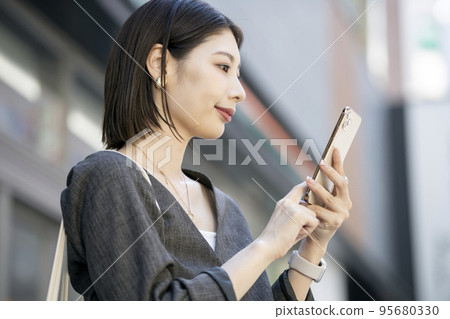 A young woman operating a smartphone A young woman operating a smartphone 95680330
