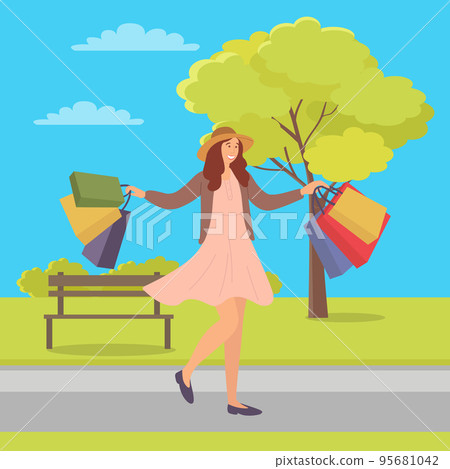Woman with shopping bags walking on the street in spring. Young girl in the park returns home 95681042