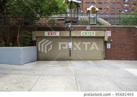 Entrance to the underground garage. Gate to the garage in the building. Office building is brown.  95681405