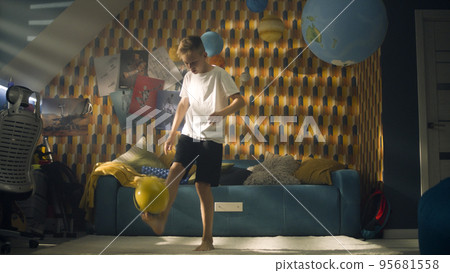 Boy pratices football in his room kicks the ball performs trick - Soccer match Boy pratices football in his room kicks the ball performs trick - Soccer match 95681558