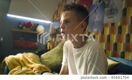 Blonde boy takes off virtual reality headset after playing intense games indoor Blonde boy takes off virtual reality headset after playing intense games indoor 95681704