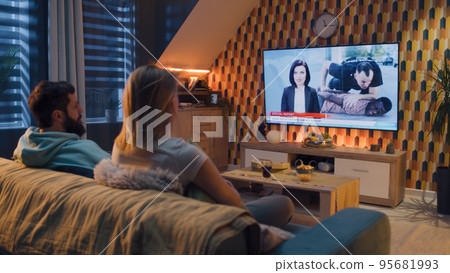 Couple watching TV news about racist police Couple watching TV news about racist police 95681993