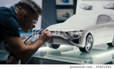 Automotive engineer makes corrections to a car sculpture using the rotary tool Automotive engineer makes corrections to a car sculpture using the rotary tool 95681994
