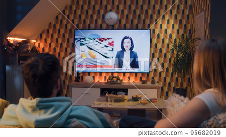 Couple watching medicine news on TV Couple watching medicine news on TV 95682019