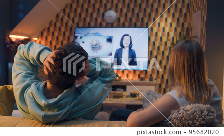 Couple watching TV news about polio in water Couple watching TV news about polio in water 95682020