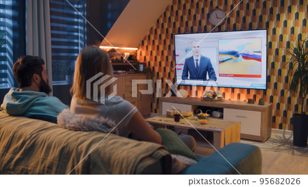 Couple watching TV news about gas conflict Couple watching TV news about gas conflict 95682026