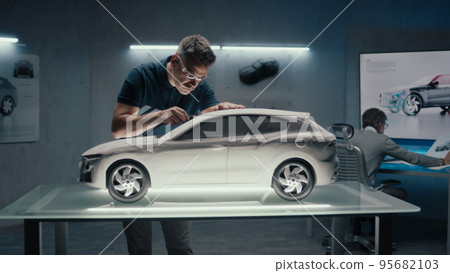 Senior automotive design engineers works on the prototype car model sculpture 95682103