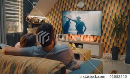 Couple watching action movie after workday 95682230