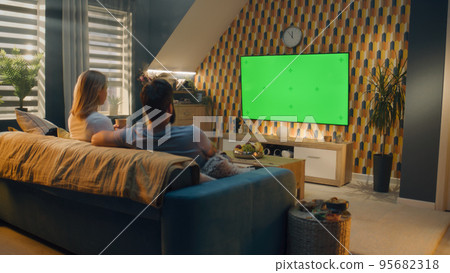 Couple watching movie on TV after work Couple watching movie on TV after work 95682318