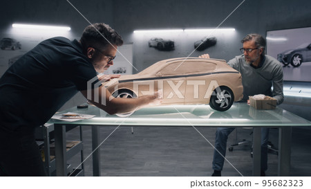 Male designers working on car model from clay Male designers working on car model from clay 95682323
